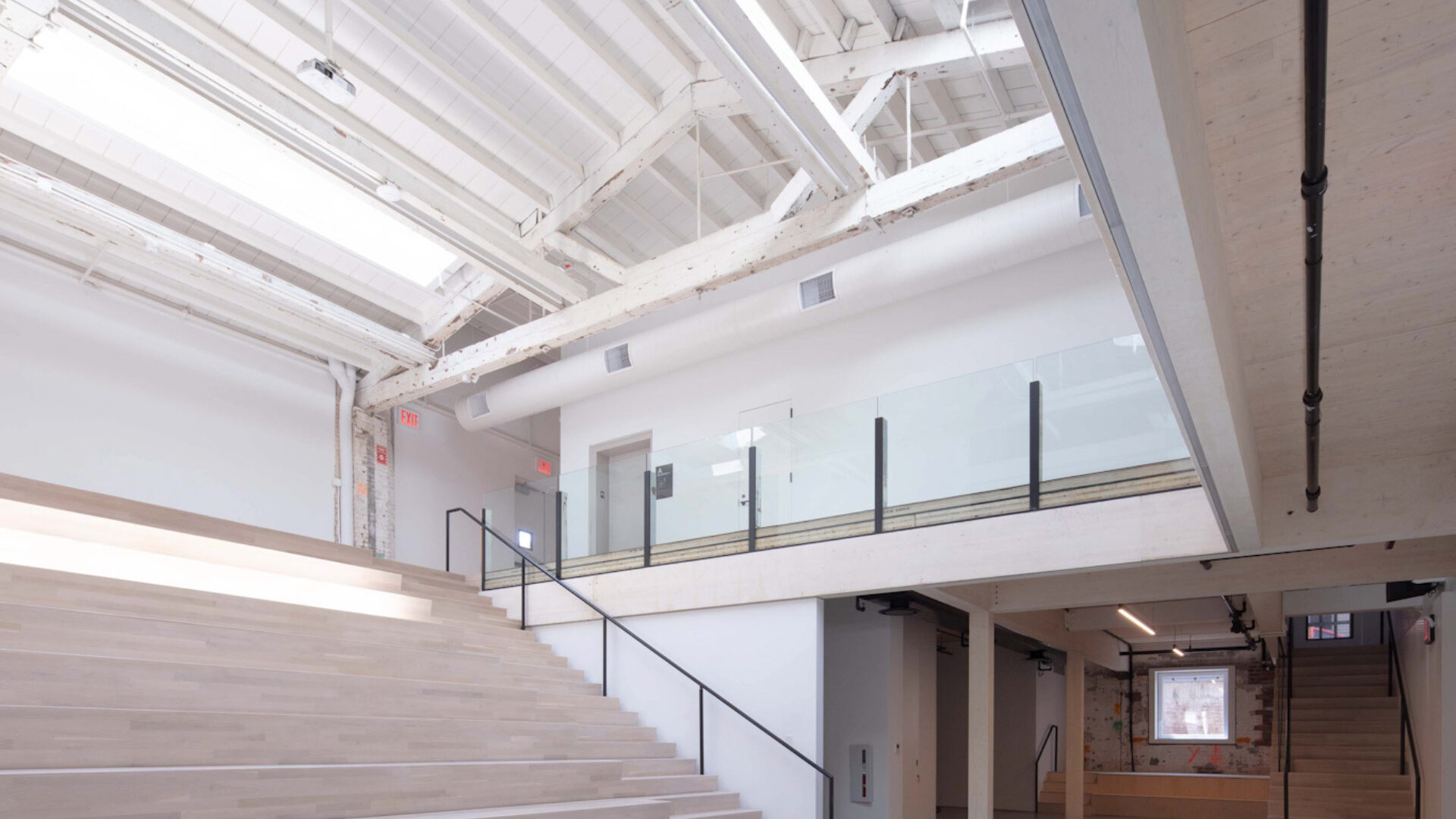 Large bank of bench seating/stairs to the left, light colored wood inside the Mercury Store building